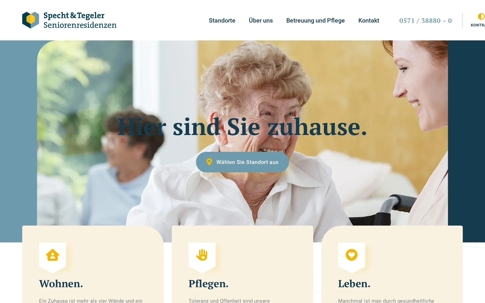 Strona główna Specht & Tegeler Seniorenresidenzen na komputerze: logo, menu z pozycjami Standorte, Über uns, Betreuung und Pflege i Kontakt, numer telefonu, przycisk „Kontrast”, zdjęcie seniorki z opiekunką, hasło „Hier sind Sie zuhause.” i trzy pola Wohnen, Pflegen, Leben